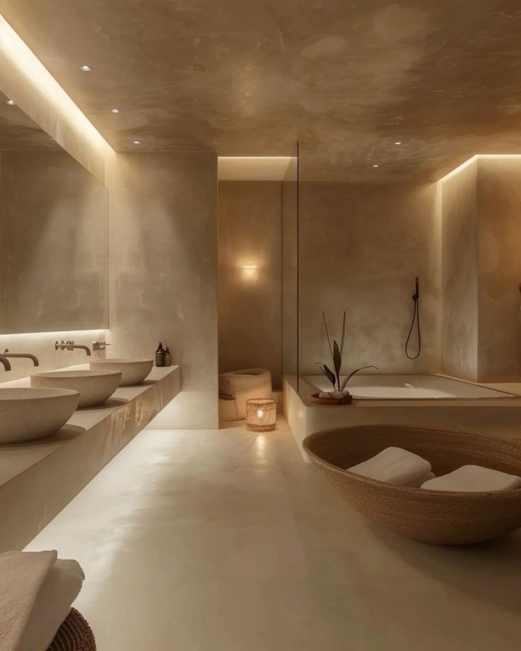 a large bathroom with two sinks and a bathtub in the middle is lit by recessed lights