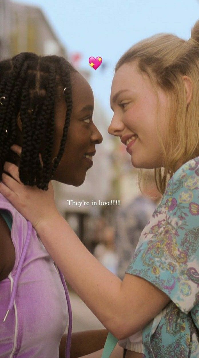 two young women standing next to each other and one has her hand on the back of another woman's shoulder