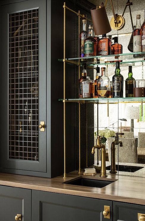 the shelves are filled with liquor bottles and other items in this kitchen area, along with an old - fashioned faucet