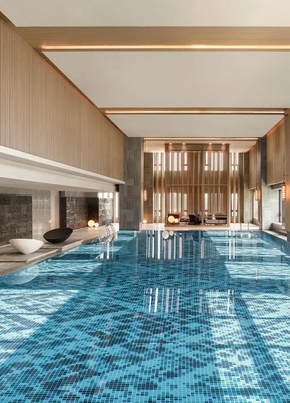 a large indoor swimming pool with blue tiles