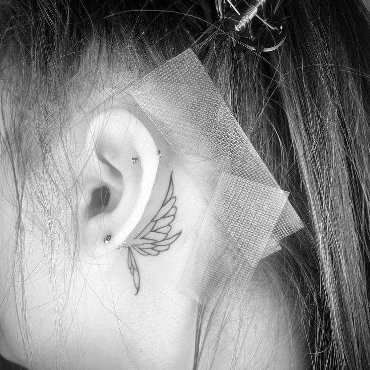 a woman with a tattoo behind her ear