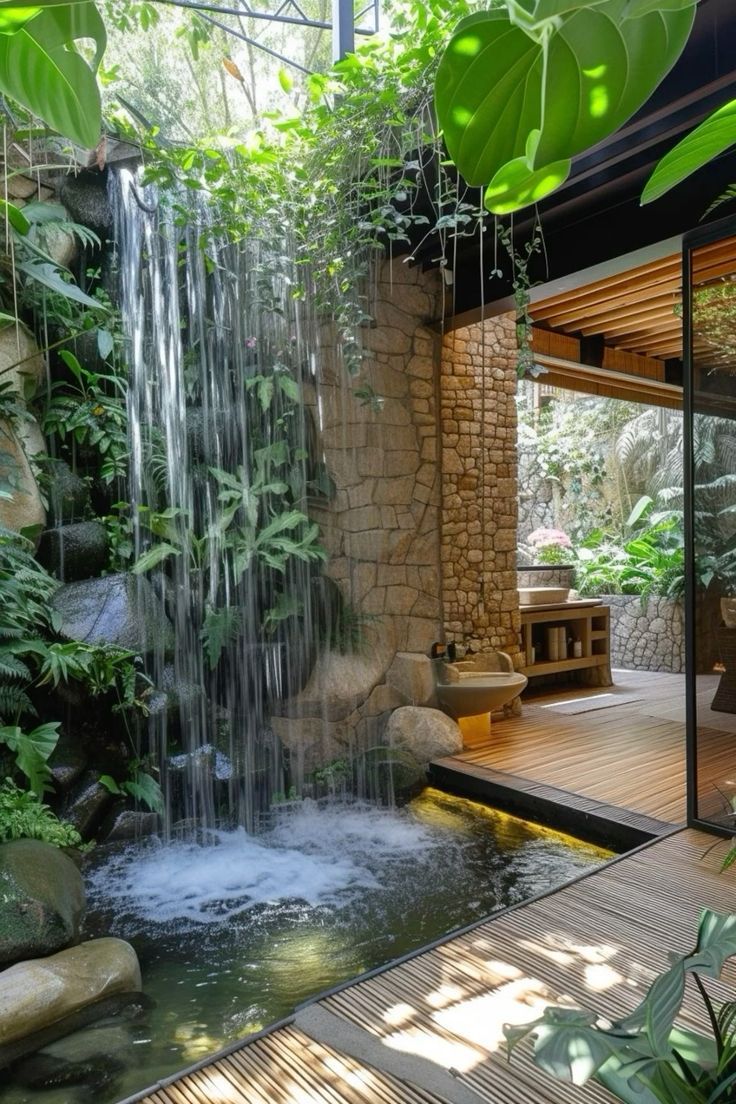 a small waterfall in the middle of a wooden decked area with plants and rocks