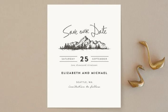 an elegant mountain wedding save the date card is shown with two gold birds on it