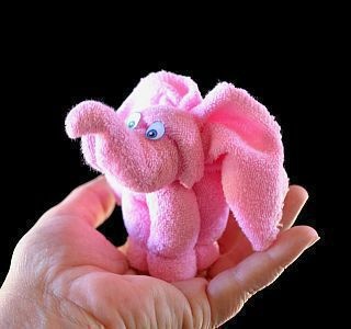 a pink stuffed animal in someone's hand