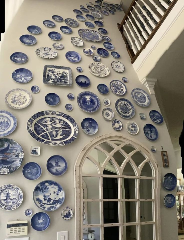 blue and white plates are arranged on the wall