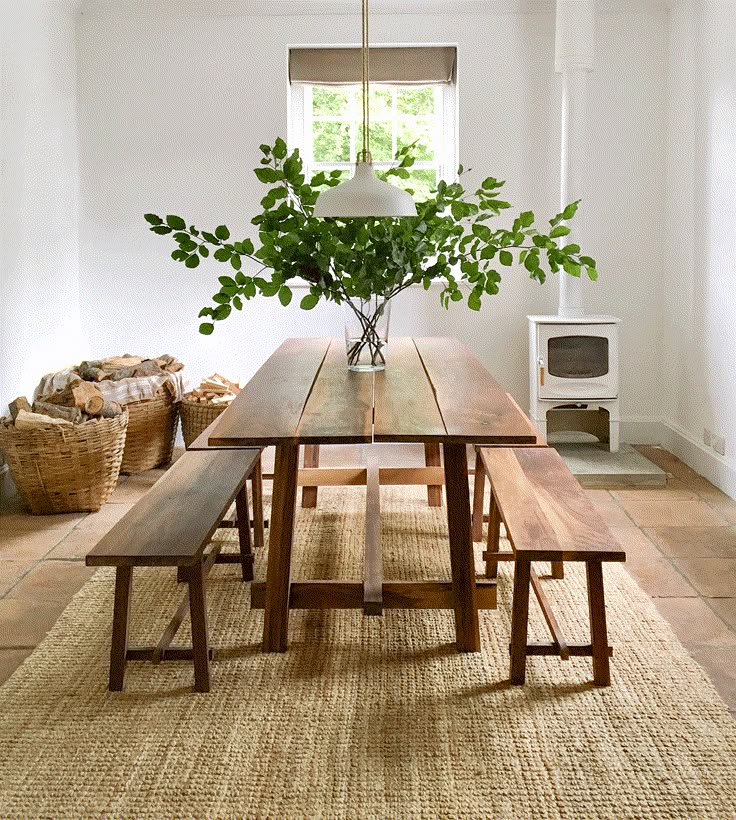 a wooden table with benches in front of it and a plant on the other side