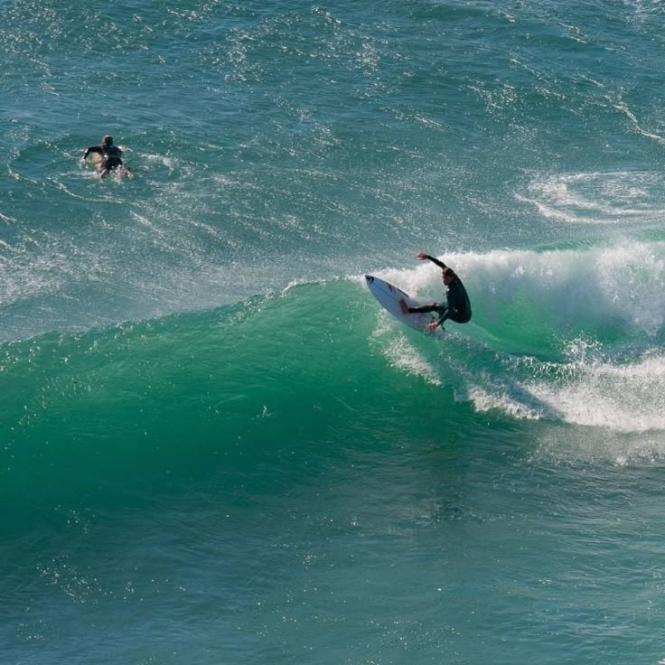 two surfers are riding the waves in the ocean