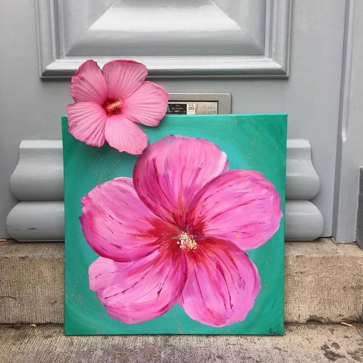 two pink flowers painted on a green background in front of a door with a radio