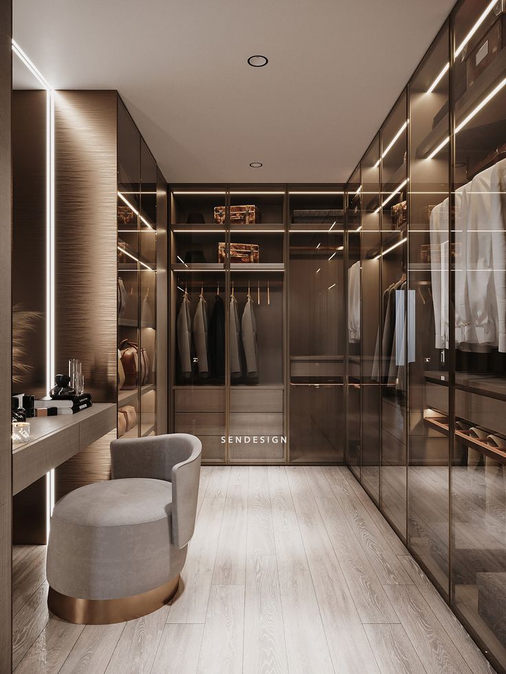 a walk - in closet with glass doors and mirrored walls is lit by recessed lighting