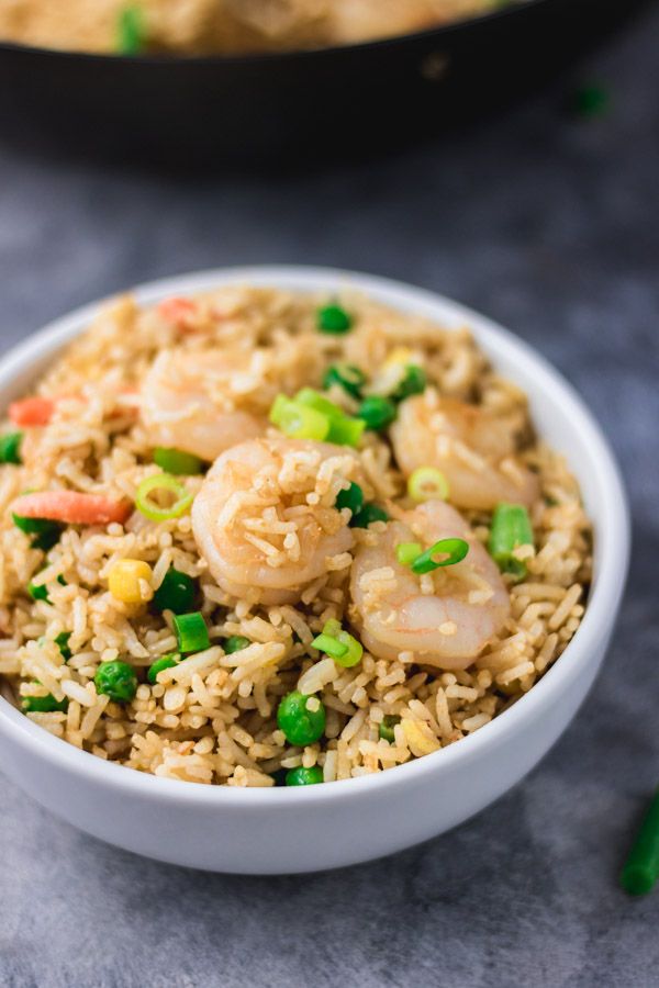 shrimp and rice with peas in a white bowl