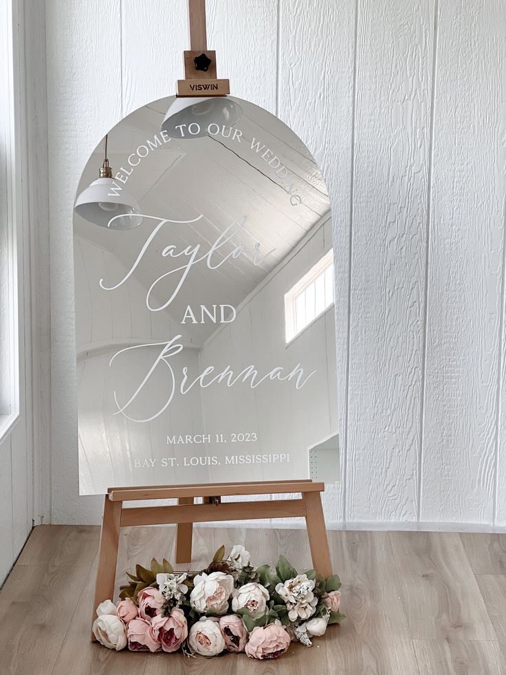 an easel with flowers on the floor and a sign that says together and bridal