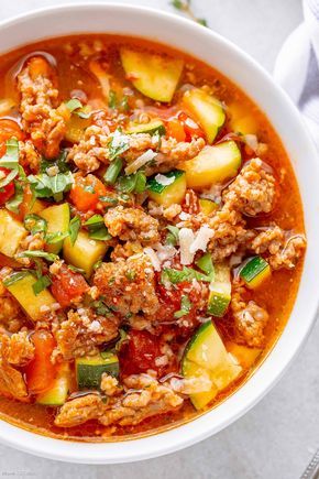 a white bowl filled with meat and vegetable soup