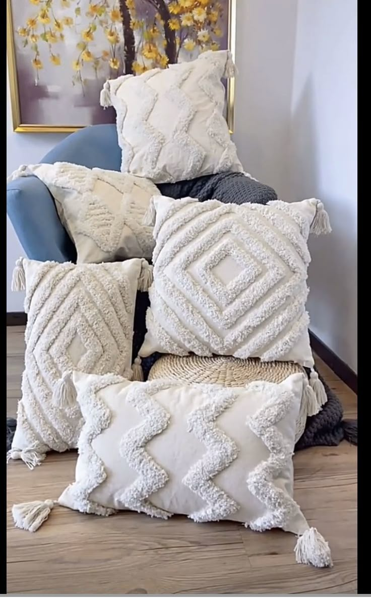 a pile of pillows sitting on top of a wooden floor