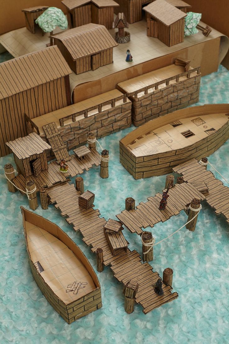 a paper model of a town with boats and buildings