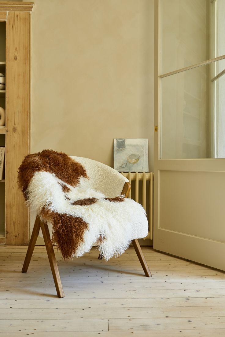 a white chair with brown and white fur on it