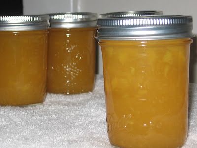 three jars filled with yellow liquid sitting on top of a white towel