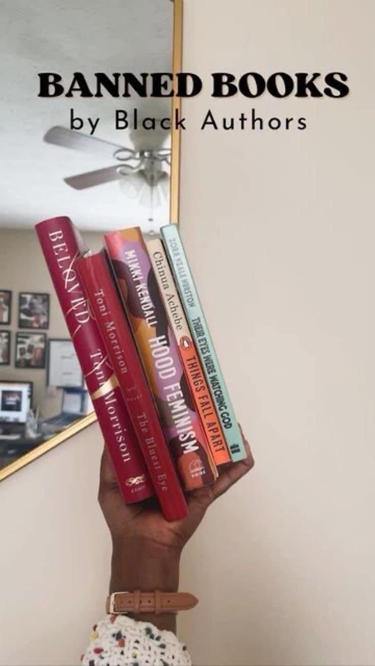 a person holding up a stack of books in front of a mirror with the title banned books by black authors