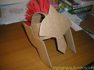 an origami horse made out of cardboard sitting on a desk next to books