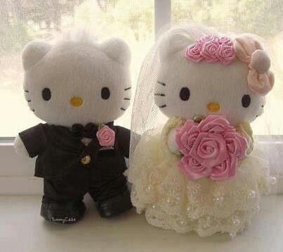 two hello kitty dolls are dressed up in wedding attire and one is holding a flower