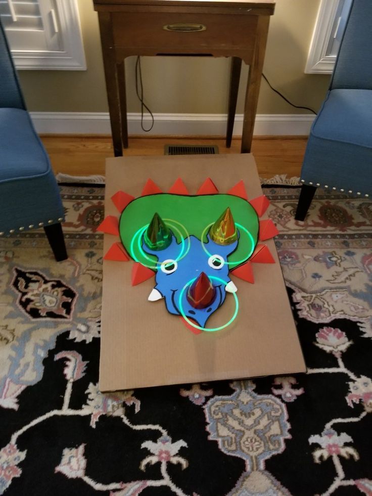 a cardboard box sitting on top of a rug in front of a table with chairs