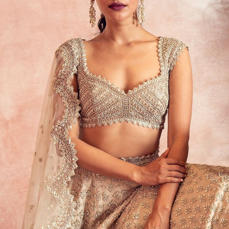 a woman in a bridal outfit posing for the camera with her hands on her hips