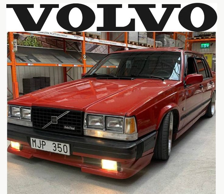 a red volvo car parked in a garage