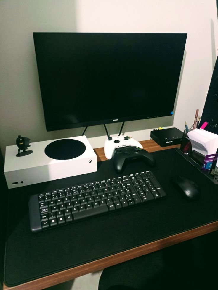 a computer desk with a keyboard, mouse and monitor on it's side in front of a large screen