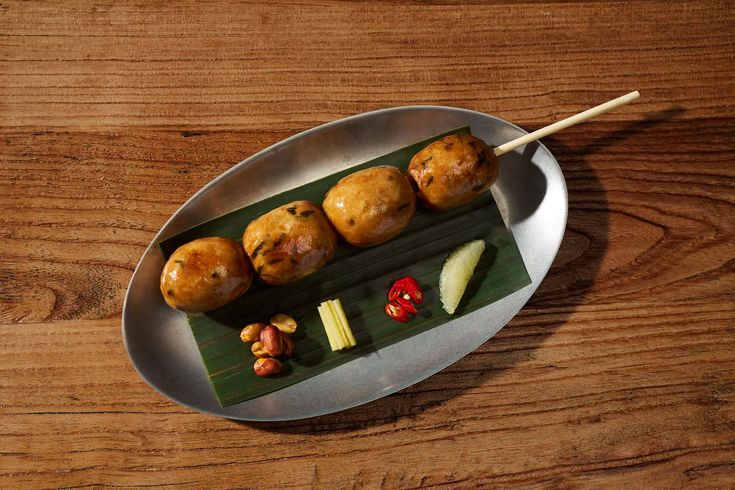 some food is sitting on a plate with chopsticks in it and ready to be eaten