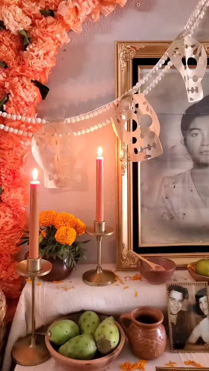 a table topped with plates and bowls filled with fruit next to a framed photo on the wall