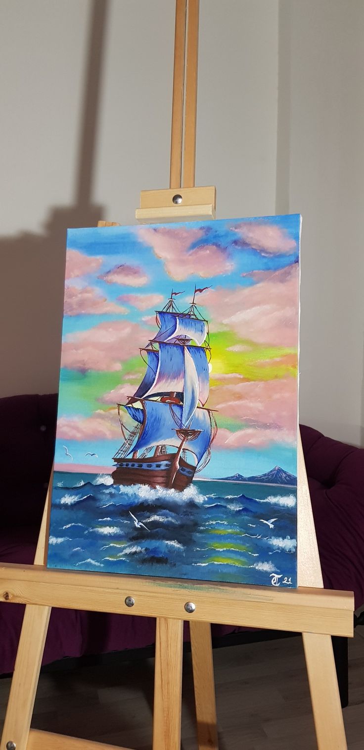 an easel with a painting of a sailboat in the ocean on it's side