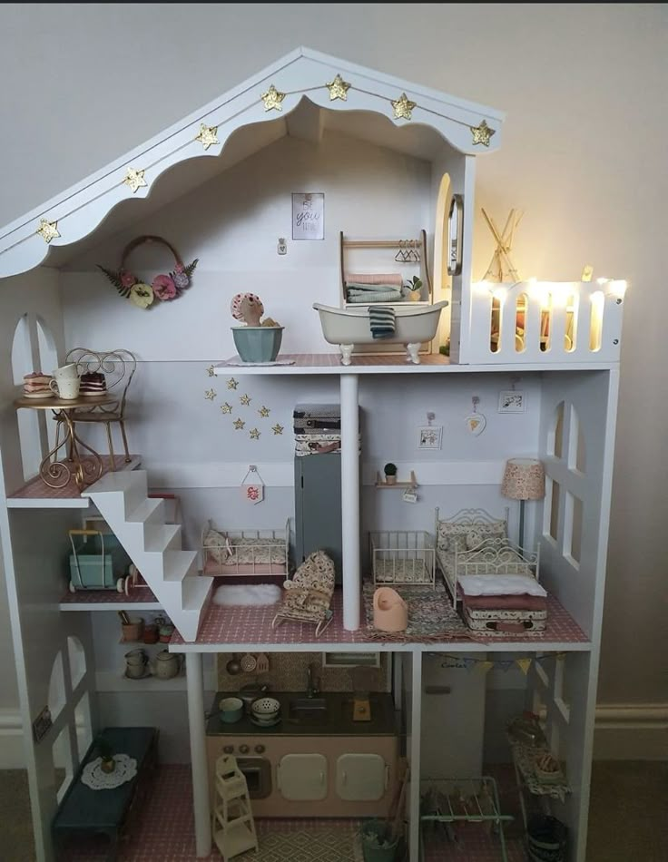 a doll house with stairs, furniture and lights on the top floor is decorated in pink and white