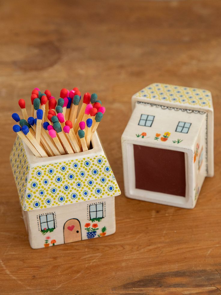 a small box with matches in it sitting next to a tiny house