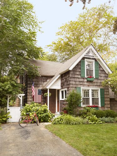 a bicycle parked in front of a house with an american flag hanging on the door