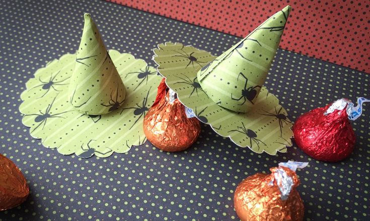 three green paper hats sitting on top of chocolate covered candies next to each other