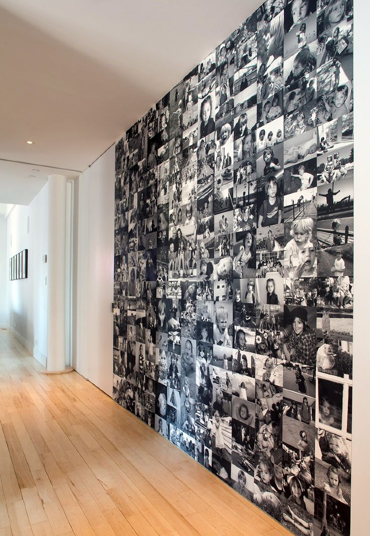 a wall covered in photos and pictures next to a hallway with wooden floors on both sides