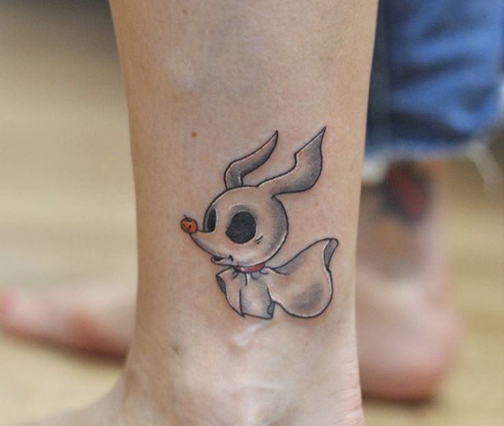 a tattoo on the foot of a person with a small dog in it's mouth