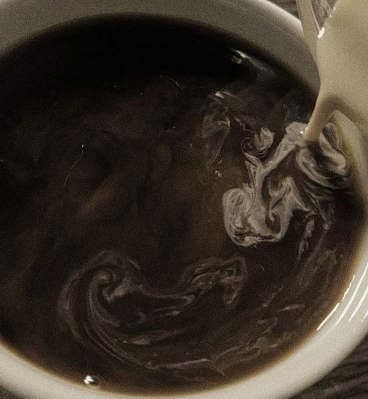 a white cup filled with liquid sitting on top of a table