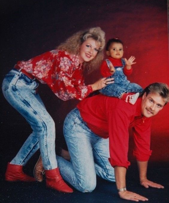 an old photo of three people posing for a picture with a doll on their lap