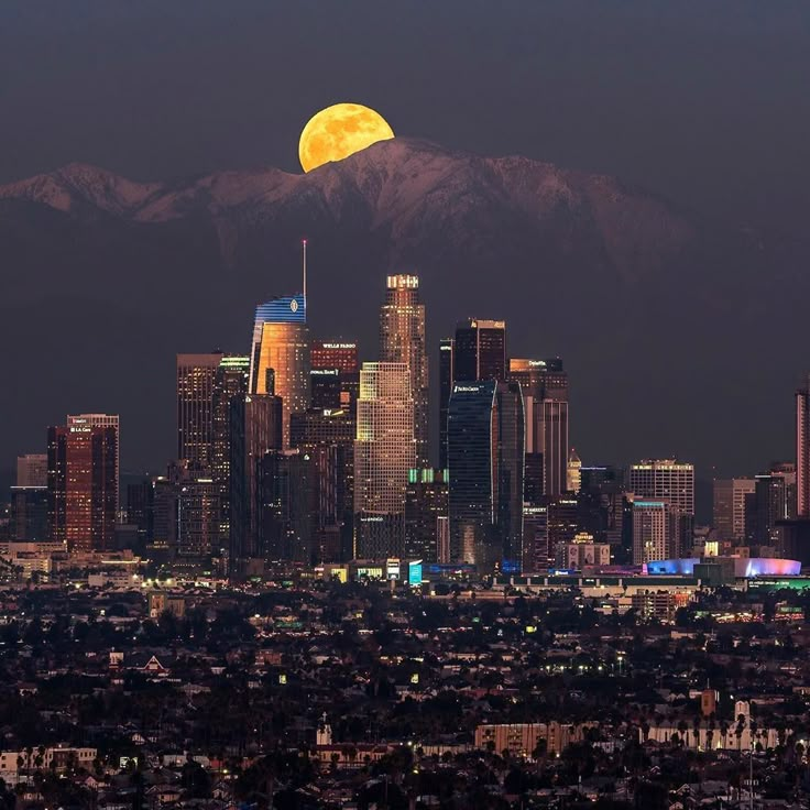 the full moon is setting over los angeles