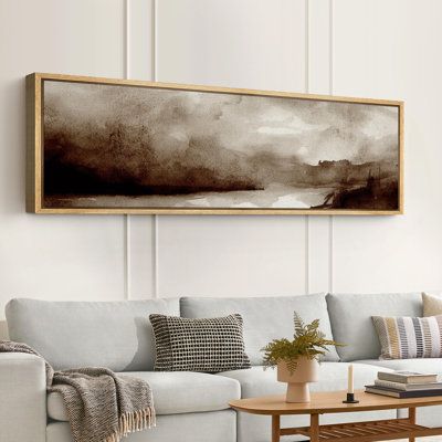 a living room with a couch, coffee table and painting on the wall above it