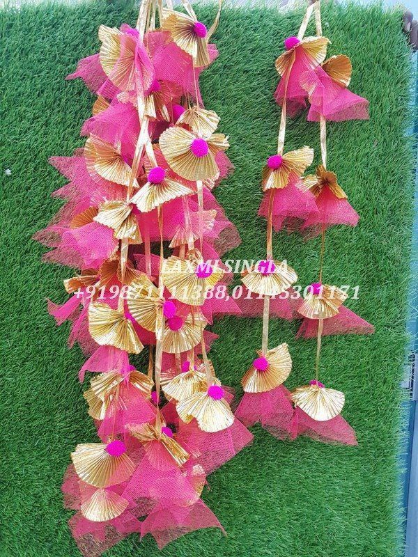 pink and gold flowers are hanging from the grass