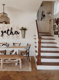 there is a table and chairs in the dining room next to the stairs that lead up to the second floor