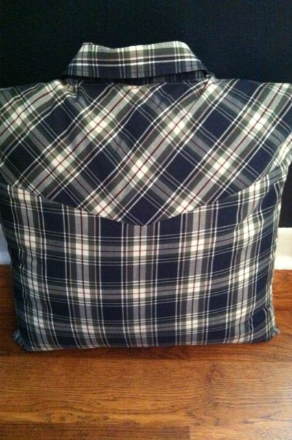 a black and white plaid bag sitting on top of a wooden floor next to a wall