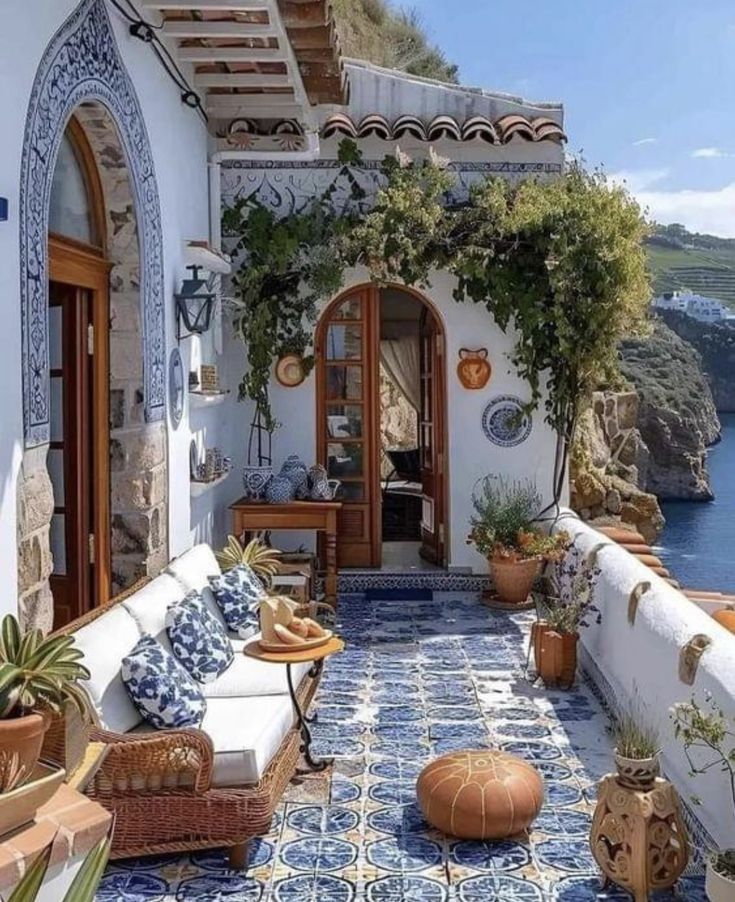 an outdoor patio with blue and white tiles on the floor, potted plants and pots