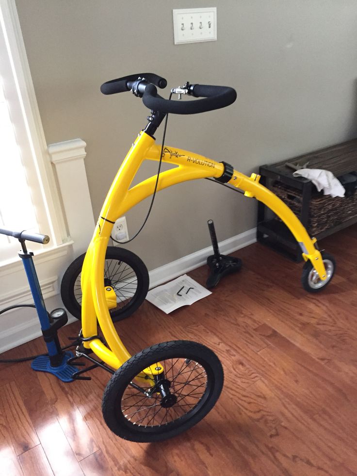 a yellow bicycle sitting on top of a hard wood floor