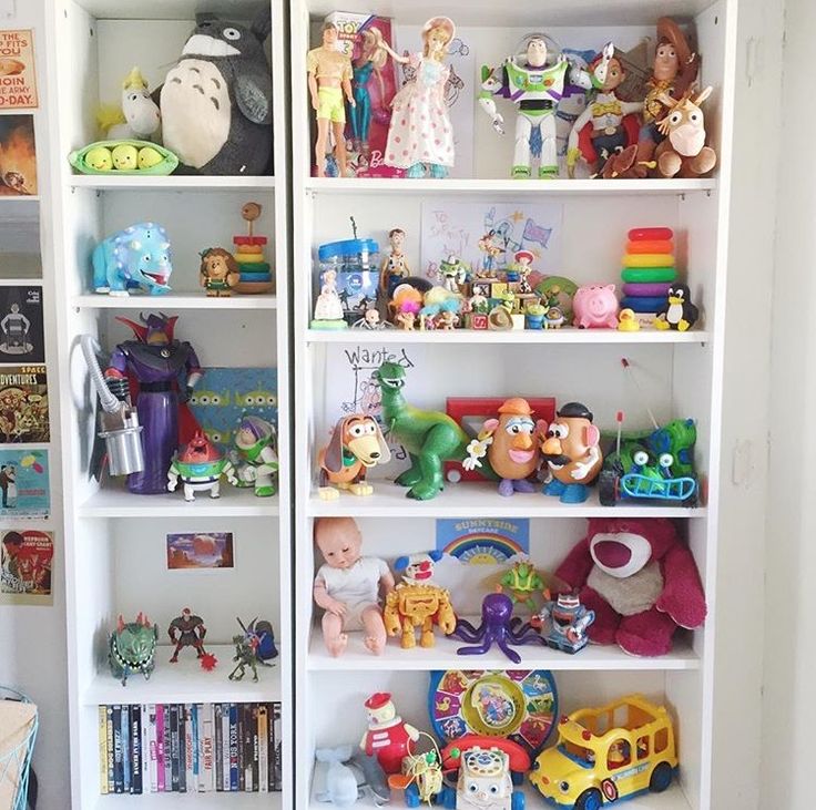 a white bookcase filled with lots of toys