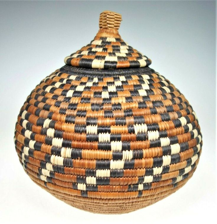 a woven basket is shown on a white surface with black and brown stripes in it