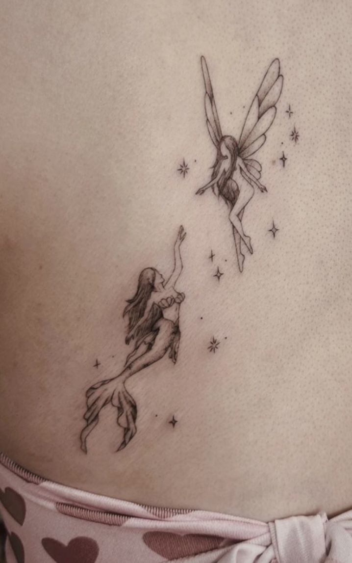 a woman with a tattoo on her stomach has a fairy tinkerbell flying through the sky