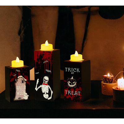 three halloween candles sitting on top of a table