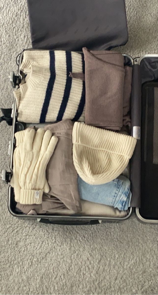 an open suitcase filled with clothes on the floor